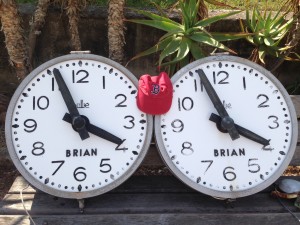 Two clocks on a bench in Menton, France.