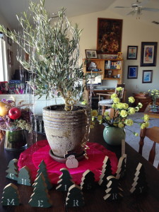 A tinselated olive Christmas tree sparkles lightlessly.