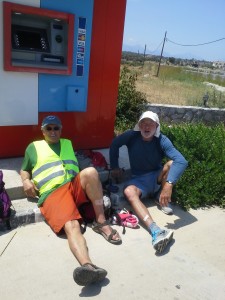 Although the MedTrek is more physical and spiritual than financial, The Idiot (seen here with MedTrekking companion Michael de Glanville) frequently rests in the shade of an ATM hoping that the heat will prompt it to automatically dispense cash. (Photo: Liz Chapin)