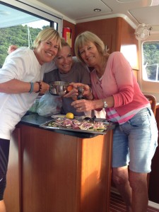 Liz Chapin, June Temple and Anne Kling prepare lunch on board the Adamus, a 39-foot catamaran.