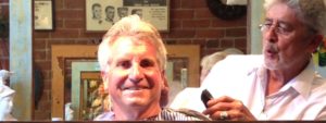 Mike Hernandez, The Idiot's barber in Redding, CA, whistles as he finishes a summer cut in his clip joint in the old Lorenz Hotel.