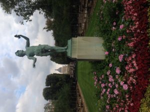 A statue of a Greek actor in Luxembourg Gardens with the Pantheon in the background.