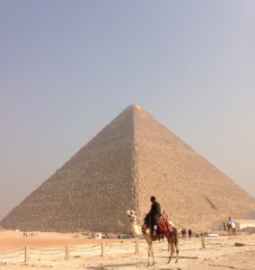 An Egyptian sitting on a camel at the pyramids in Giza.