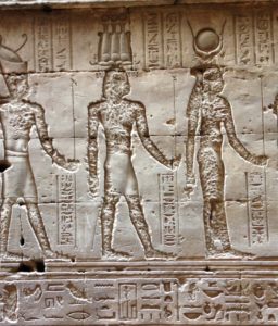 Egyptians walking on a wall at the temple at Edfu on the Nile River.